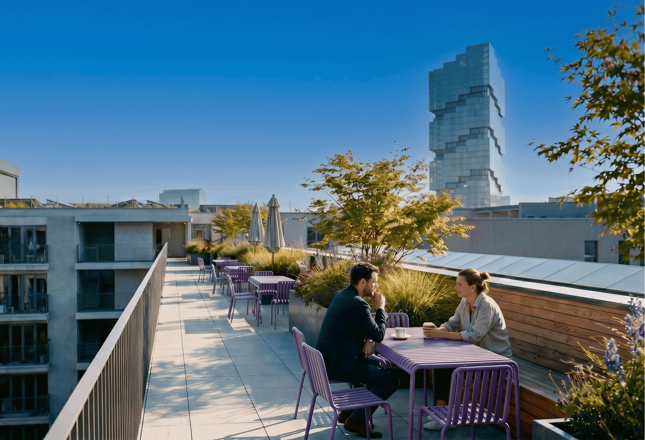 Dachterrasse von FRIEDRICH: zwei Personen sitzen bei Kaffee an einem lilafarbenen Bistrotisch zwischen Ziergräsern und Hochbeeten, im Hintergrund die Berliner Dachlandschaft mit einem gestuften Glashochhaus.